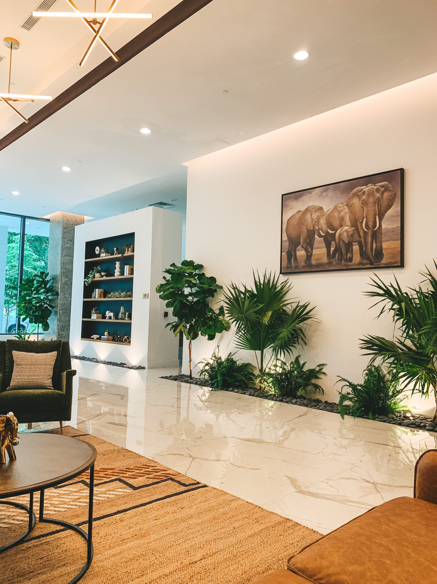 Lobby art wall with elephant painting and tropical plants